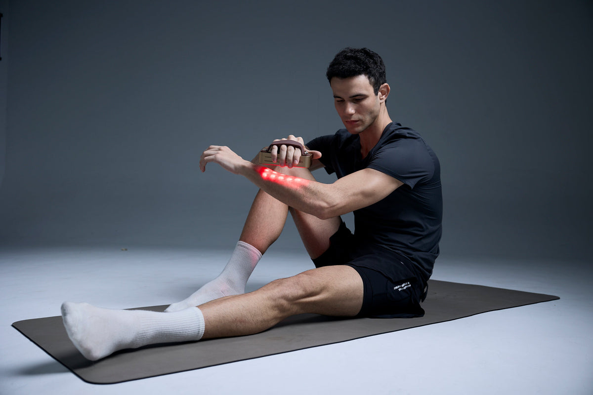 Athlete using a red light therapy panel on their legs after a training session in a home gym