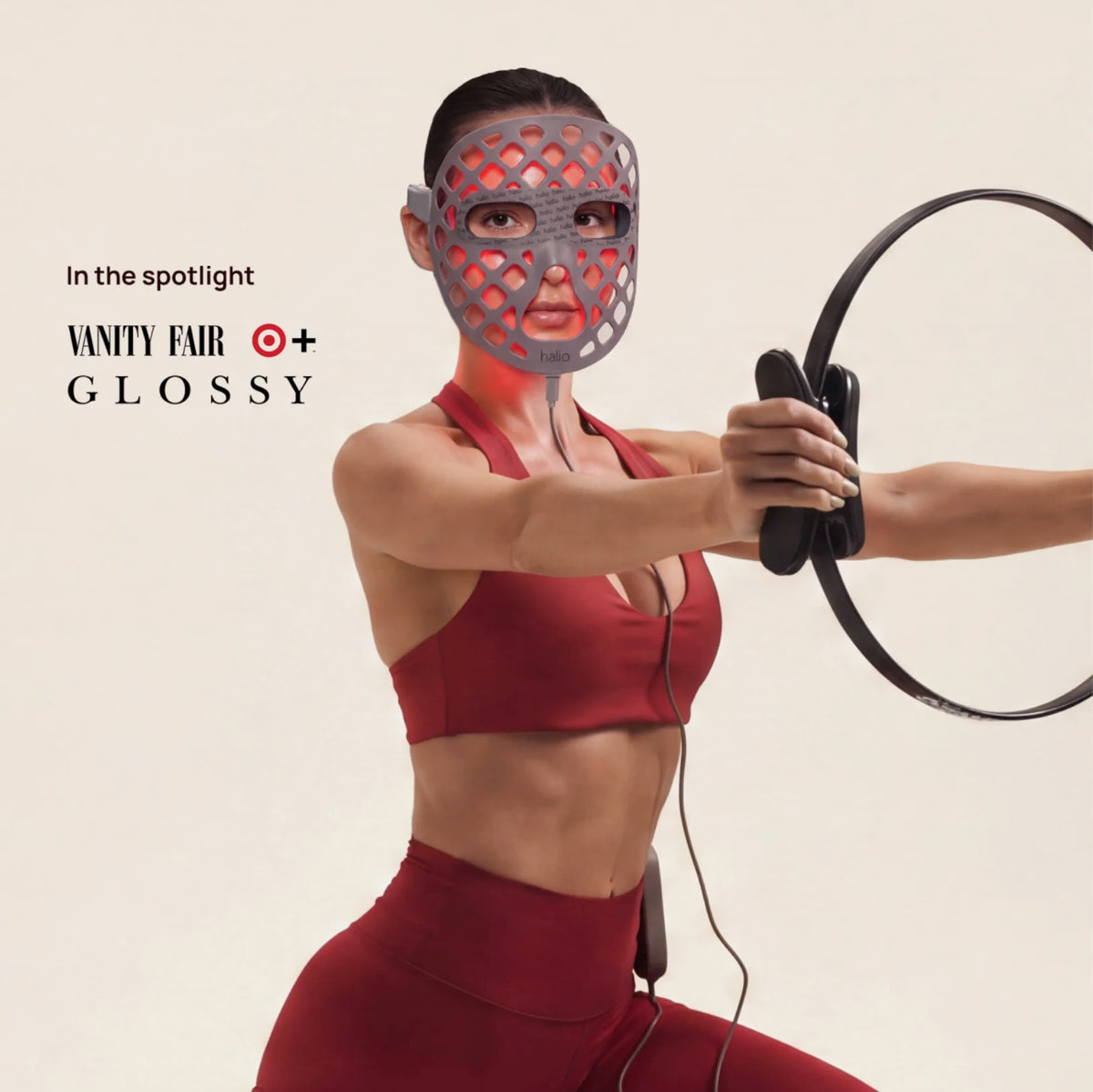 Model wearing a Halio LED face mask while using a handheld circular device; text reads “In the spotlight,” “VANITY FAIR,” and “GLOSSY.”