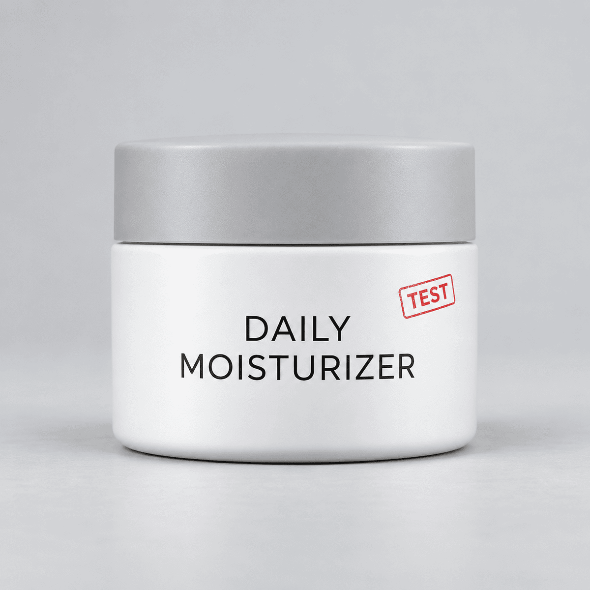 White jar of [TEST] Daily Moisturizer with a silver lid and red TEST stamp.